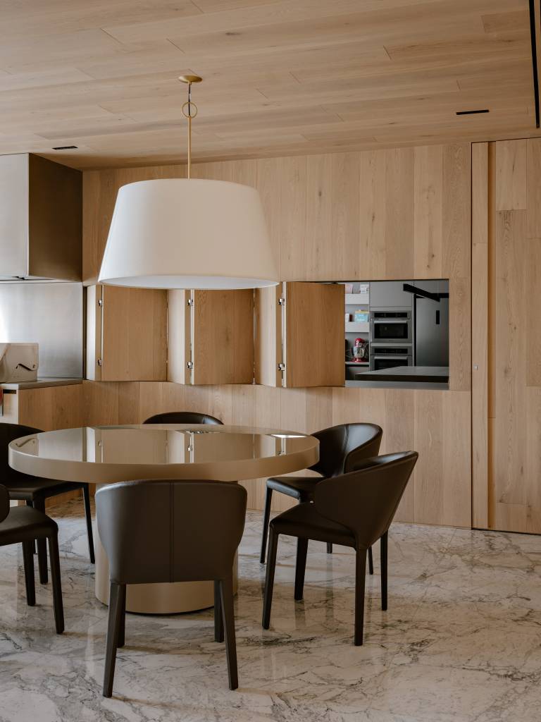 Apartamento amplo tem piso de mármore e painéis de madeira como divisórias. Projeto de DB Arquitetos.