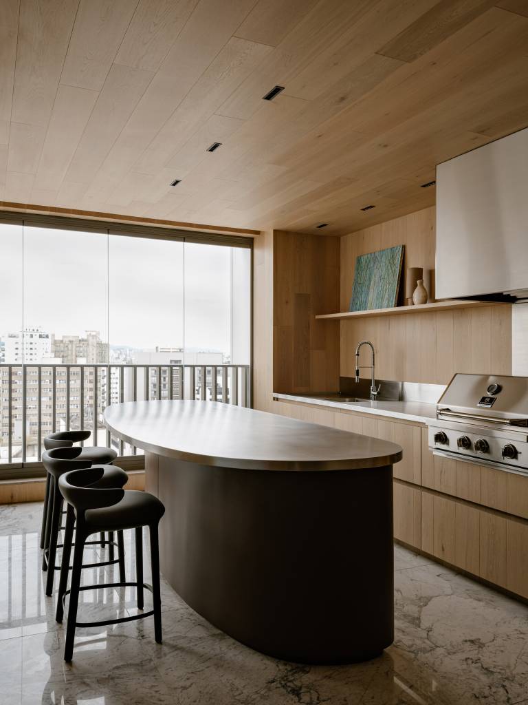 Apartamento amplo tem piso de mármore e painéis de madeira como divisórias. Projeto de DB Arquitetos.