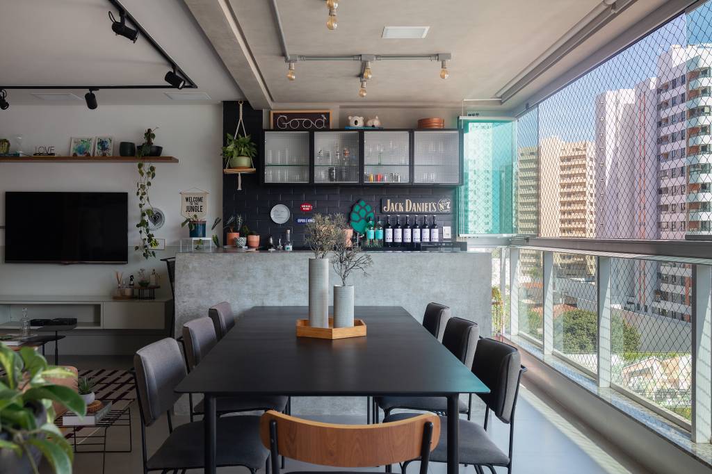 Apartamento descolado tem meia parede verde na sala e varanda gourmet industrial