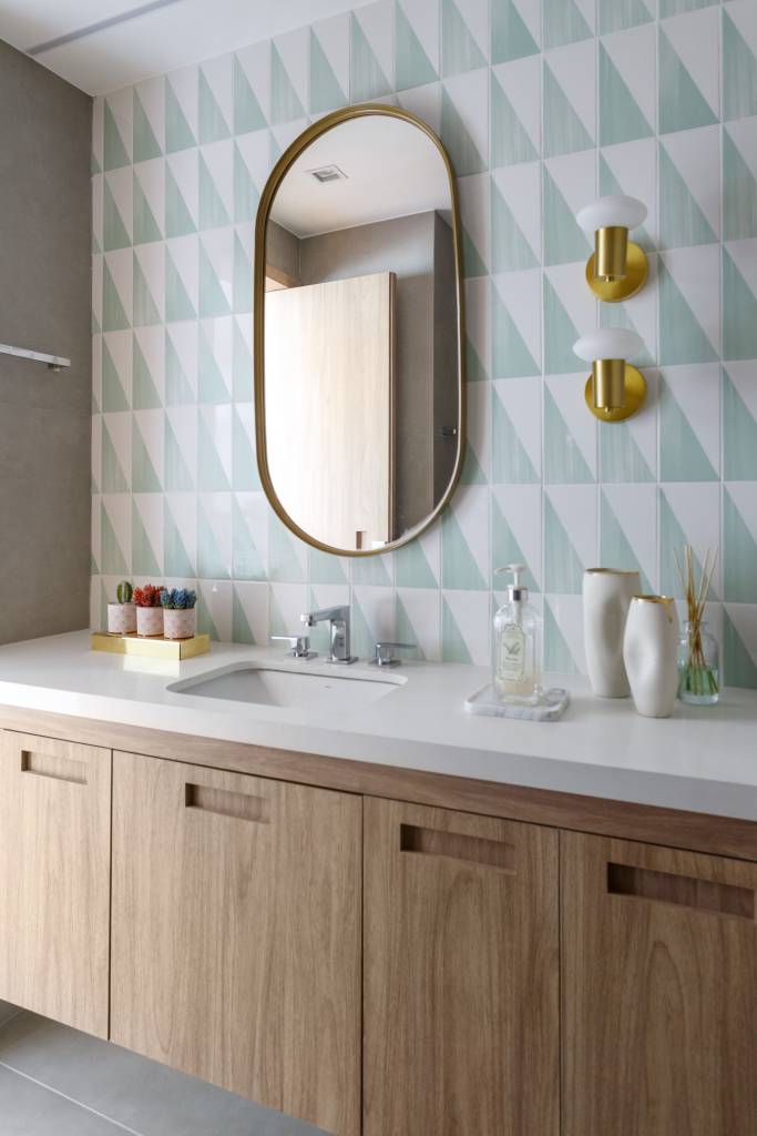 Apartamento tem parede de tijolinhos e MDF azul petróleo na cozinha. Projeto de Vita Arquitetura.