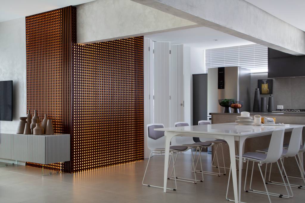 Apê elegante em tons de cinza tem painel de muxarabi iluminado com tela tensionada