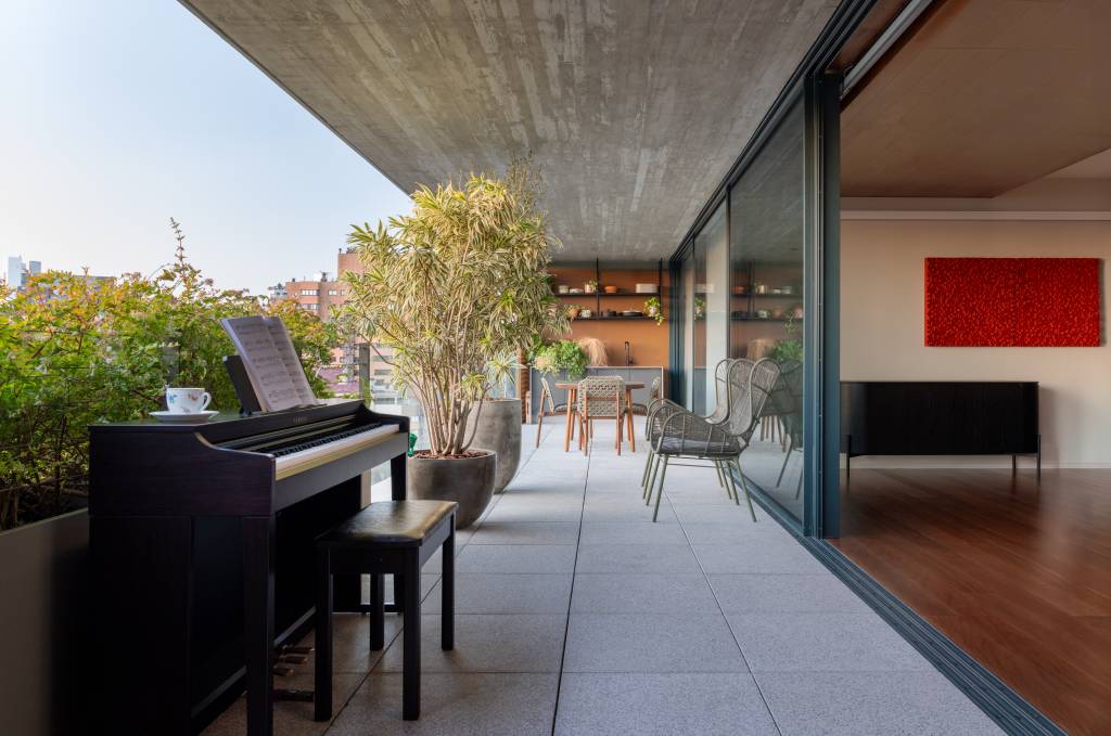 Esquadrias piso-teto integram varanda gourmet ao living deste apartamento