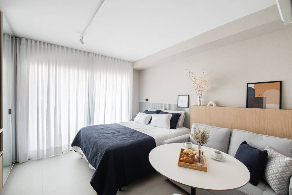 Miniapartamento de 24 m² tem sofá-cama e cozinha linear completa. Projeto de VilaVille Arquitetura.