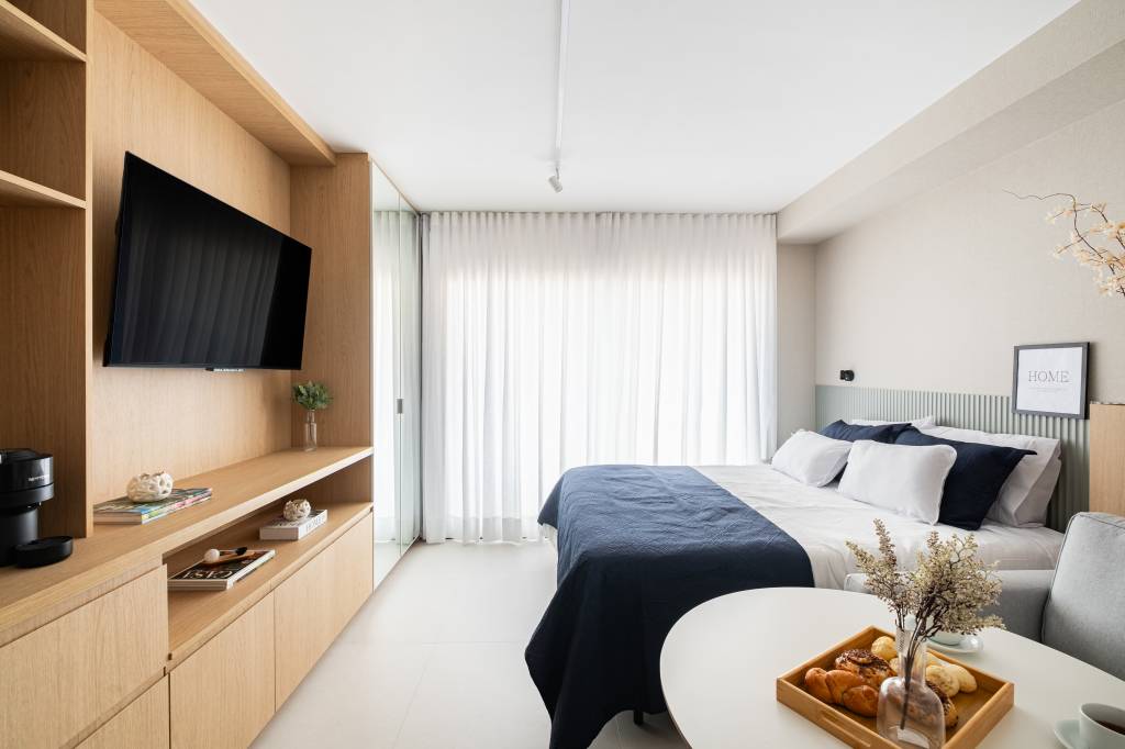 Miniapartamento de 24 m² tem sofá-cama e cozinha linear completa. Projeto de VilaVille Arquitetura.