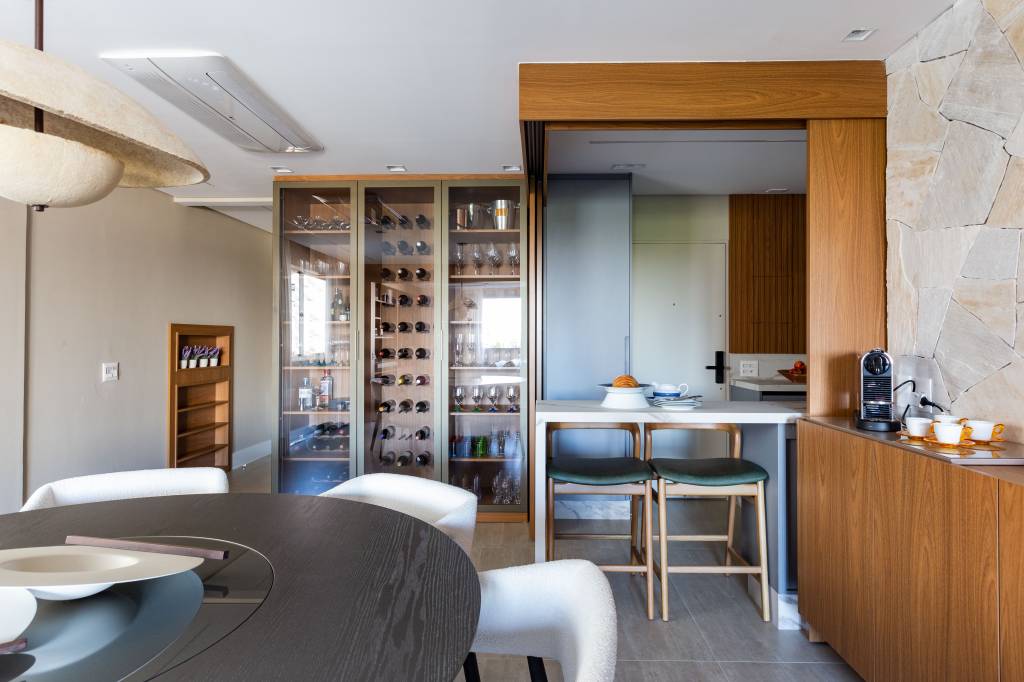 Apartamento tem cozinha com ilha que pode ficar integrada ou não. Projeto de Daniela Funari.