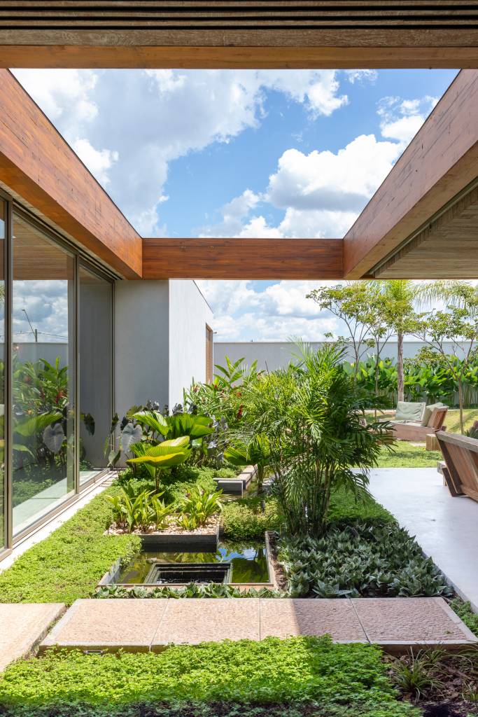 Casa de 517 m² tem estilo contemporâneo e jardim com lago. Projeto Solange Calio