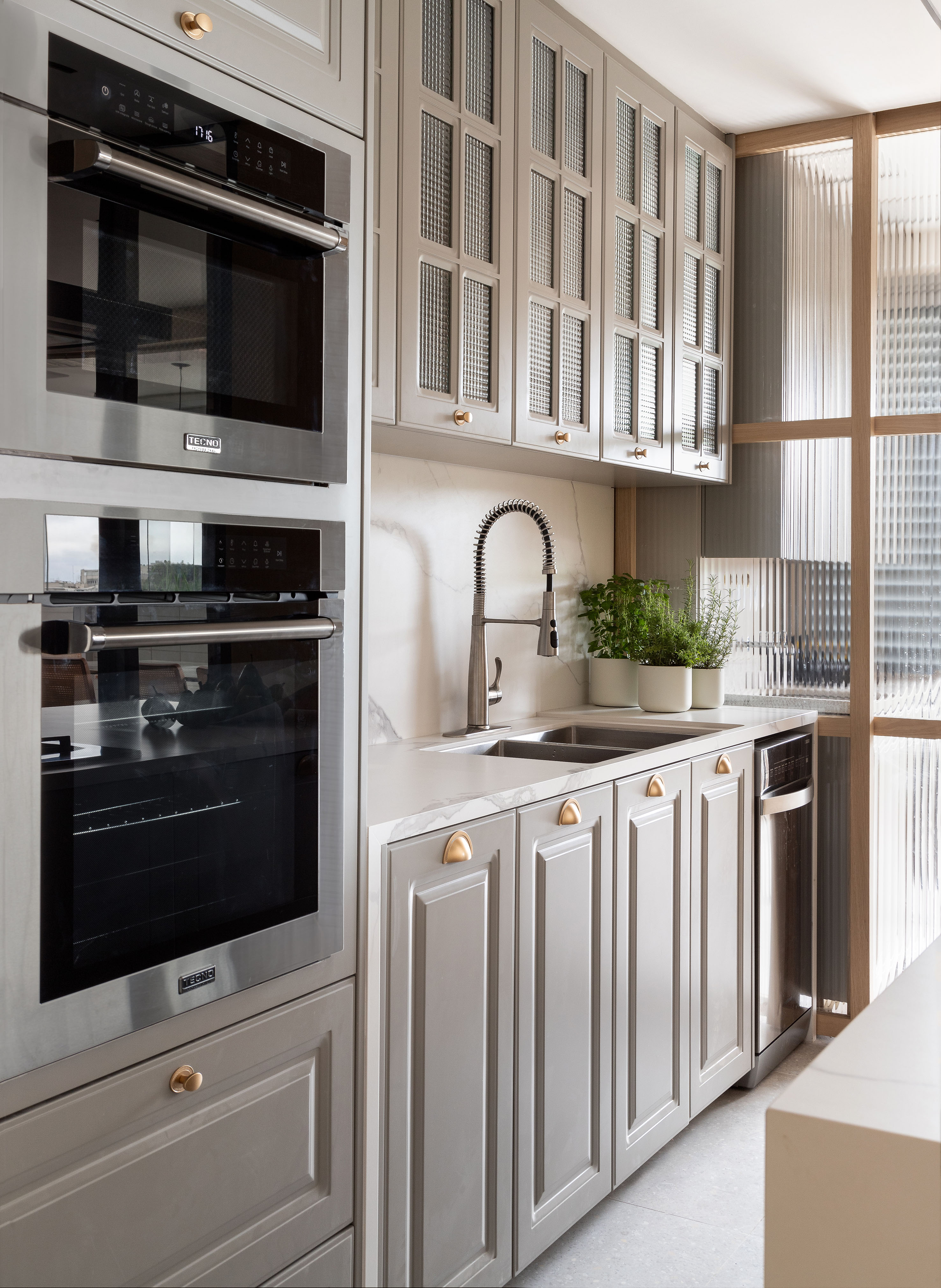 Cozinha provençal cinza integrada é destaque neste apartamento no Rio. Projeto de Patty Coelho Arquitetura.