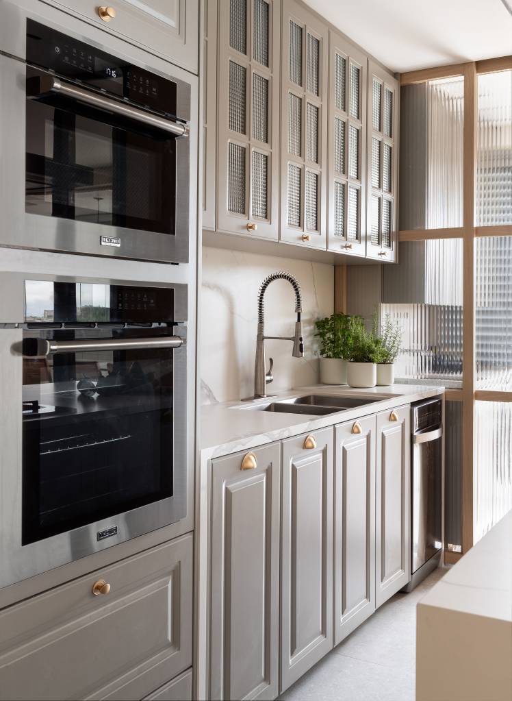 Cozinha provençal cinza integrada é destaque neste apartamento no Rio. Projeto de Patty Coelho Arquitetura.