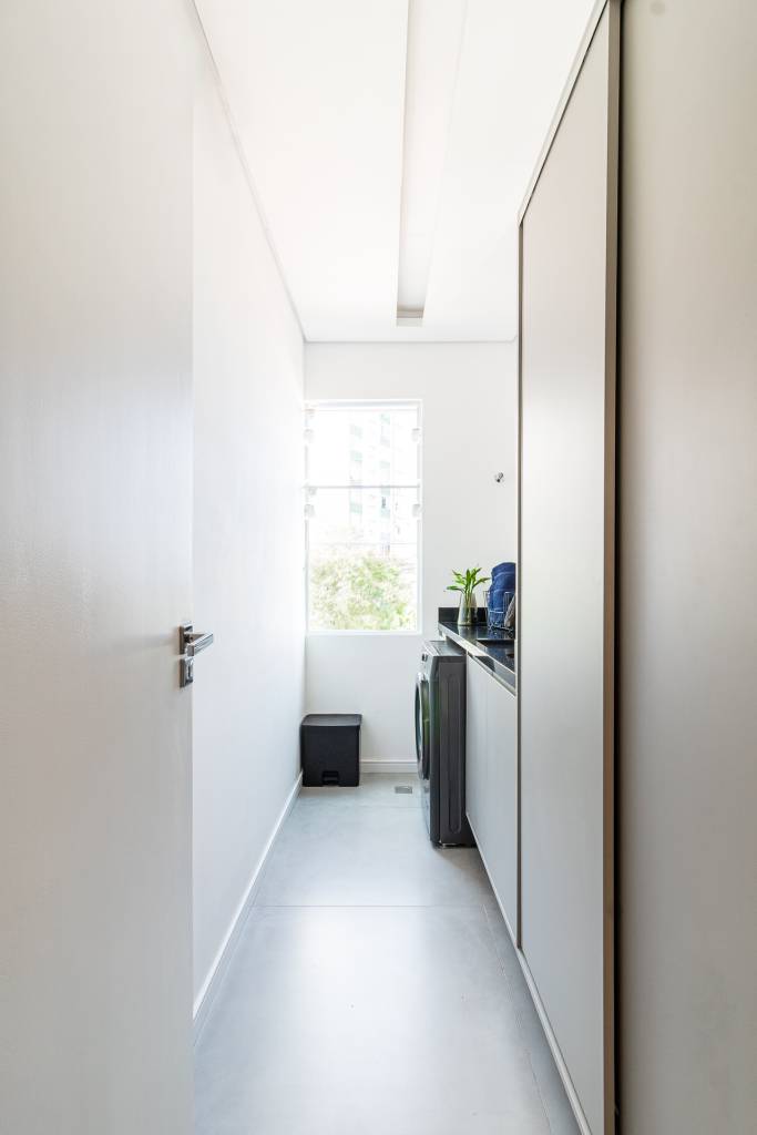 Kitnet de 33m² ganha área de serviço e cozinha integrada à sala após reforma. Projeto de Bimá Arquitetura. Área de serviço.