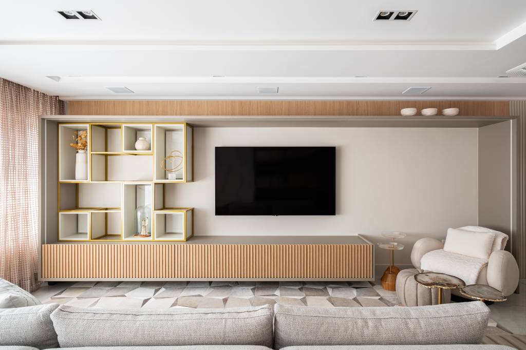 Apê com decoração clássica tem boiseries, cristaleira espelhada e lareira