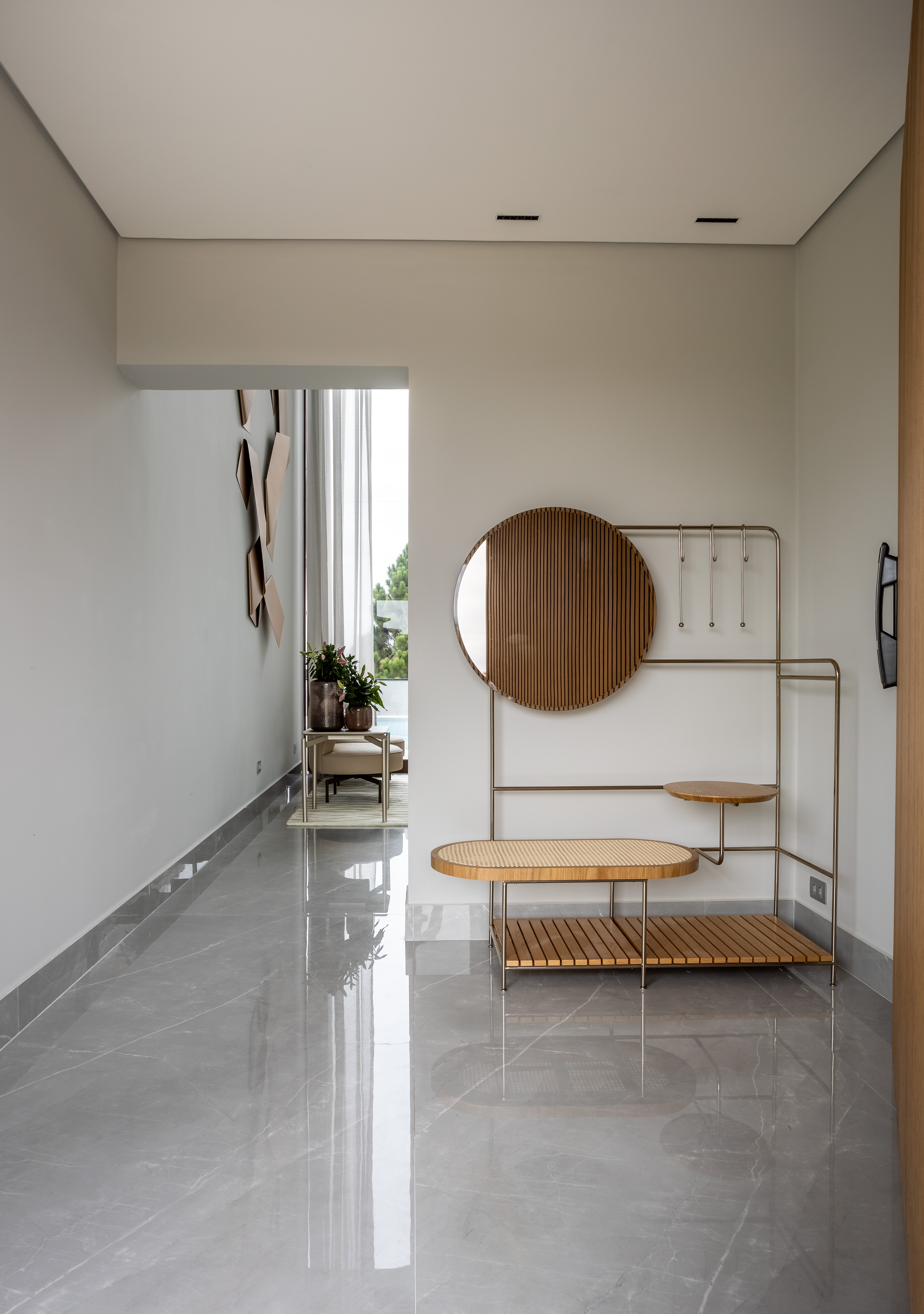 Casa na Granja Viana tem escada de porcelanato plissada, cabeceira de pedra e cristaleira divisória. Projeto de Meneghisso & Pasquotto Arquitetura.