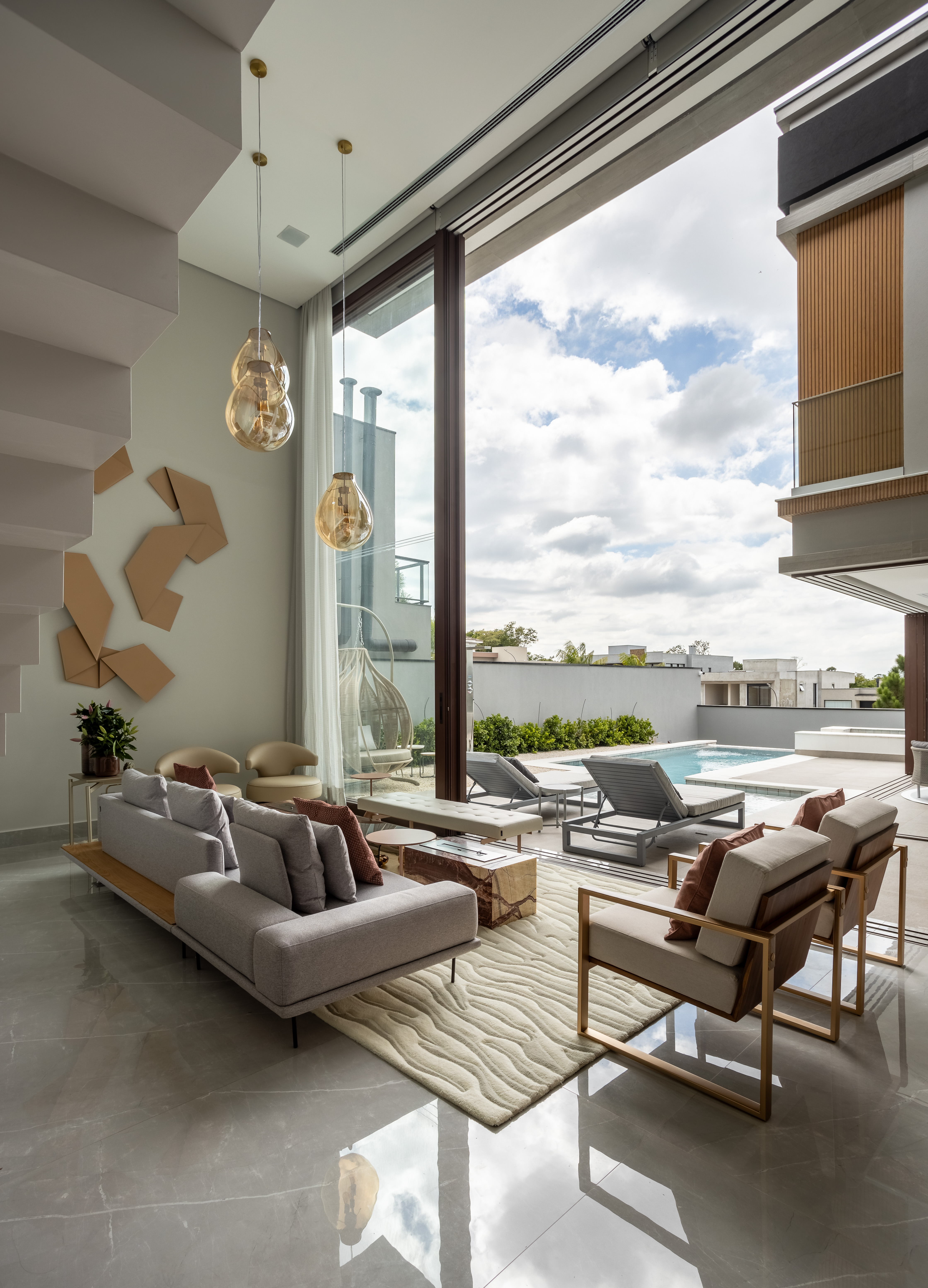 Casa na Granja Viana tem escada de porcelanato plissada, cabeceira de pedra e cristaleira divisória. Projeto de Meneghisso & Pasquotto Arquitetura.