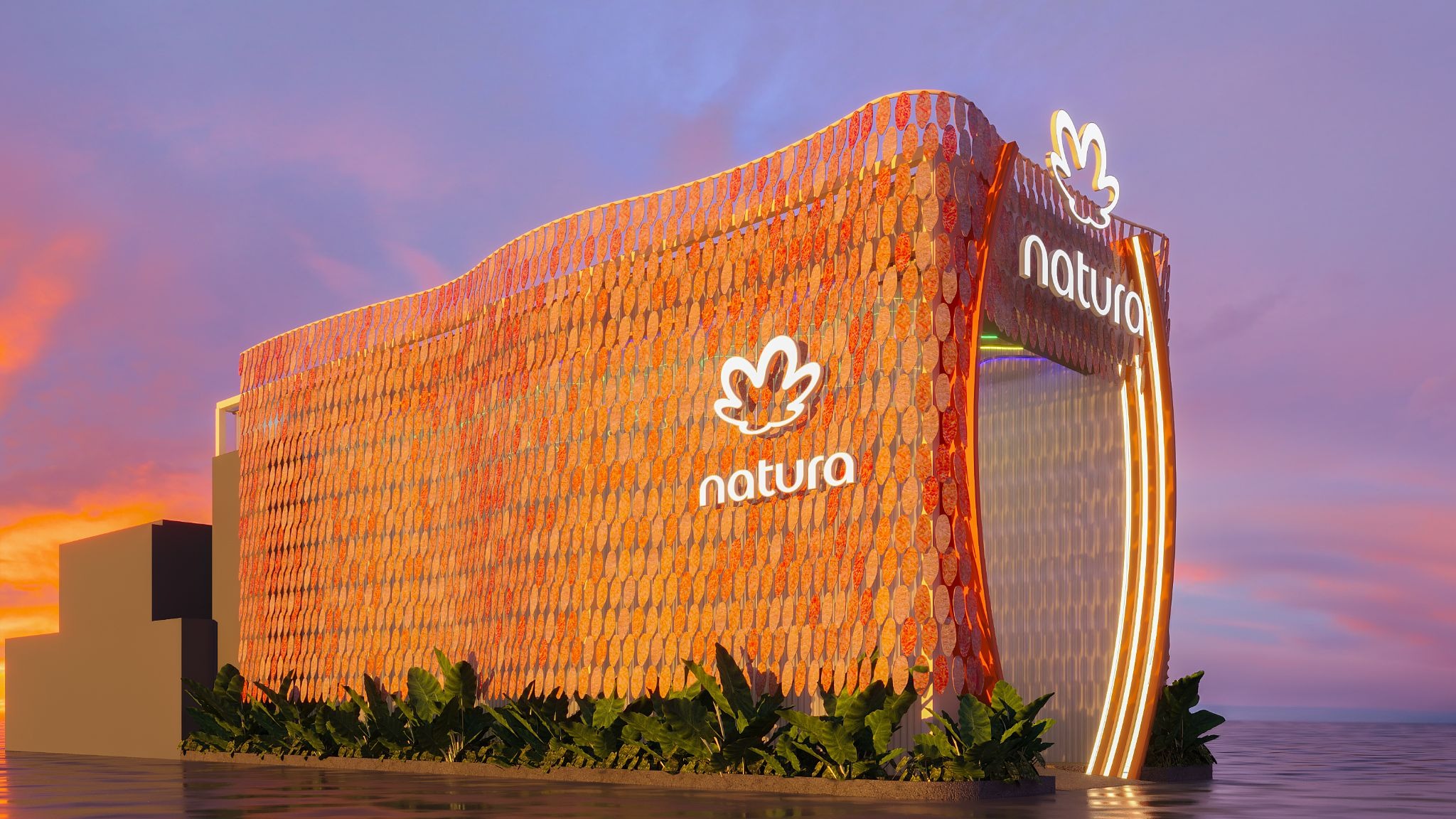 Estrutura moderna da Natura com fachada de folhas alaranjadas e logo iluminado, sobre a água, sob um céu de pôr do sol roxo e laranja